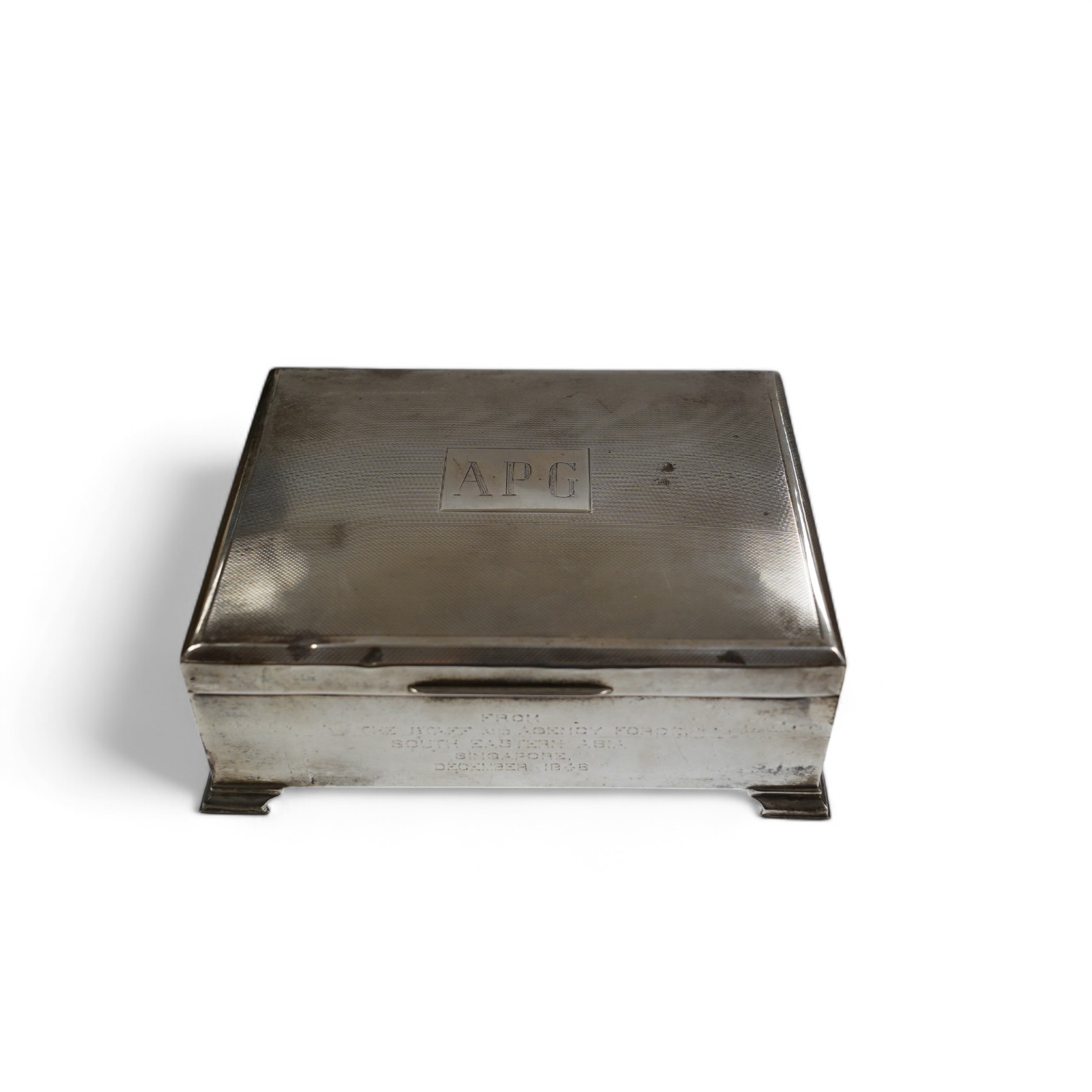 A George VI part engine turned silver cigarette box, Birmingham, 1948, with engraved inscription, on bracket feet, 17.3cm. Condition - poor